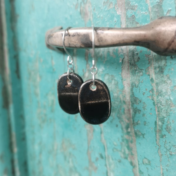 Orecchini ovali in ceramica fatti a mano, nei colori nero e bronzo