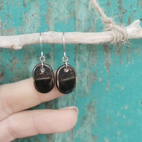 Orecchini ovali in ceramica fatti a mano, nei colori nero e bronzo