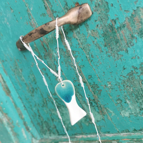 Collana di pesce in ceramica infilata su perline di vetro 