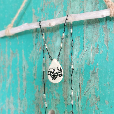 Collana in ceramica con motivo pressato in stile vintage infilata su perle
