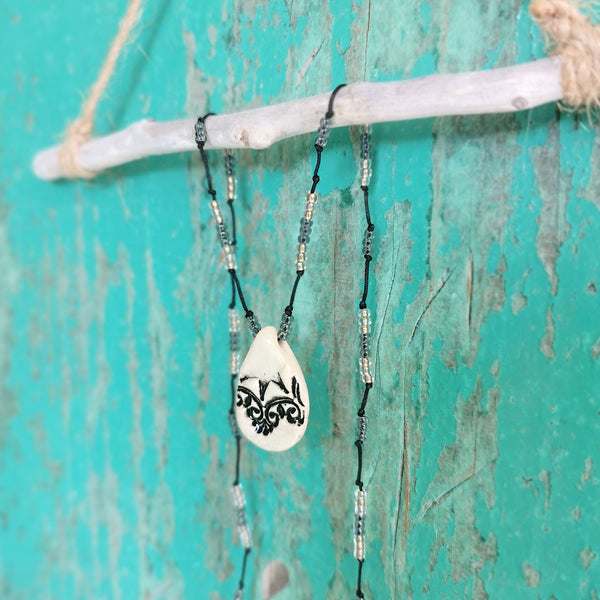 Collana in ceramica con motivo pressato in stile vintage infilata su perle