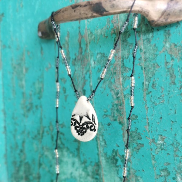 Collana in ceramica con motivo pressato in stile vintage infilata su perle