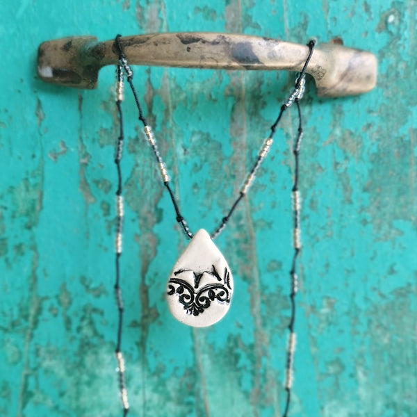 Collana in ceramica con motivo pressato in stile vintage infilata su perle