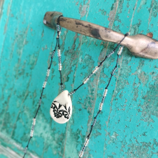 Collana in ceramica con motivo pressato in stile vintage infilata su perle