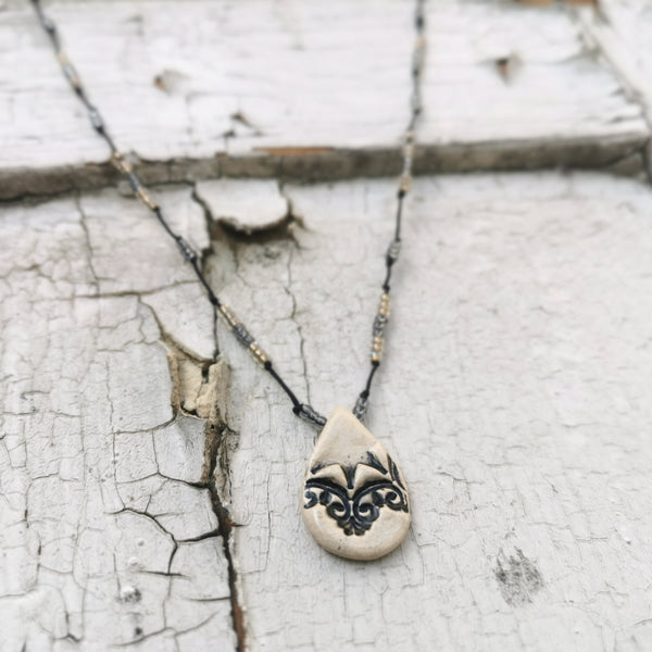 Collana in ceramica con motivo pressato in stile vintage infilata su perle