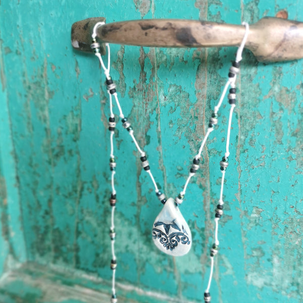 Collana in ceramica con motivo pressato in stile vintage infilata su perle