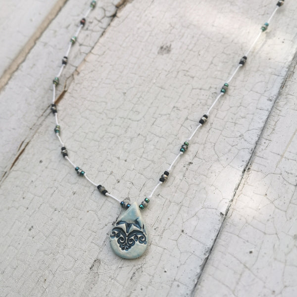 Collana in ceramica con motivo pressato in stile vintage infilata su perle