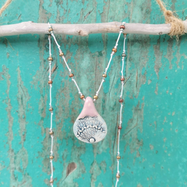Collana in ceramica con motivo pressato rustico infilata su perle