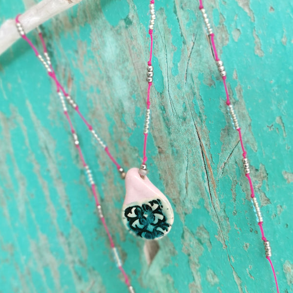 Collana in ceramica con motivo pressato rustico infilata su perle
