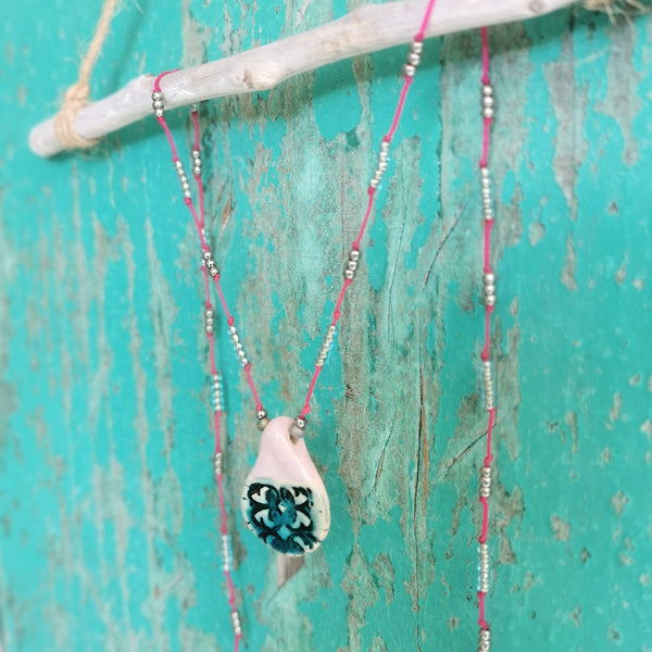 Collana in ceramica con motivo pressato rustico infilata su perle