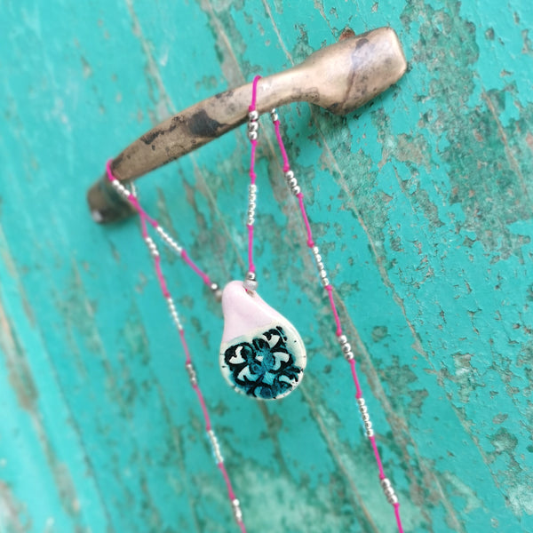 Collana in ceramica con motivo pressato rustico infilata su perle