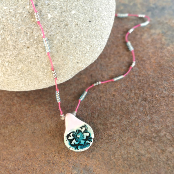 Collana in ceramica con motivo pressato rustico infilata su perle