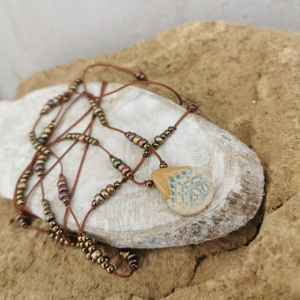 Collana in ceramica con motivo pressato rustico infilata su perle con bracciale 