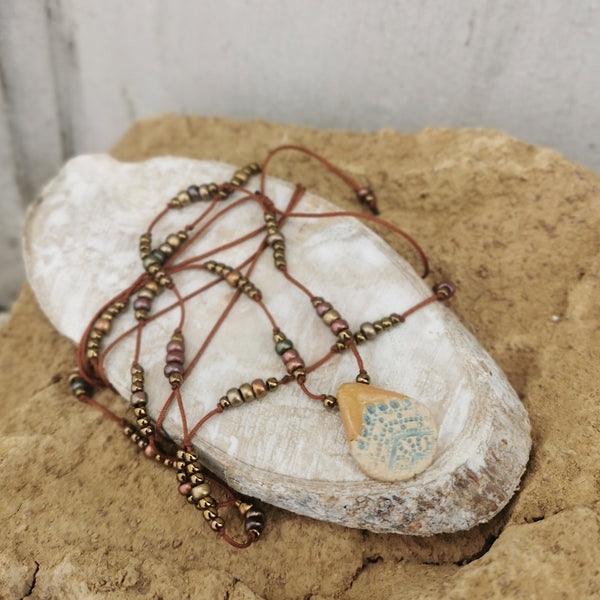 Collana in ceramica con motivo pressato rustico infilata su perle con bracciale 