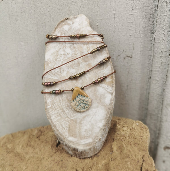 Collana in ceramica con motivo pressato rustico infilata su perle con bracciale 